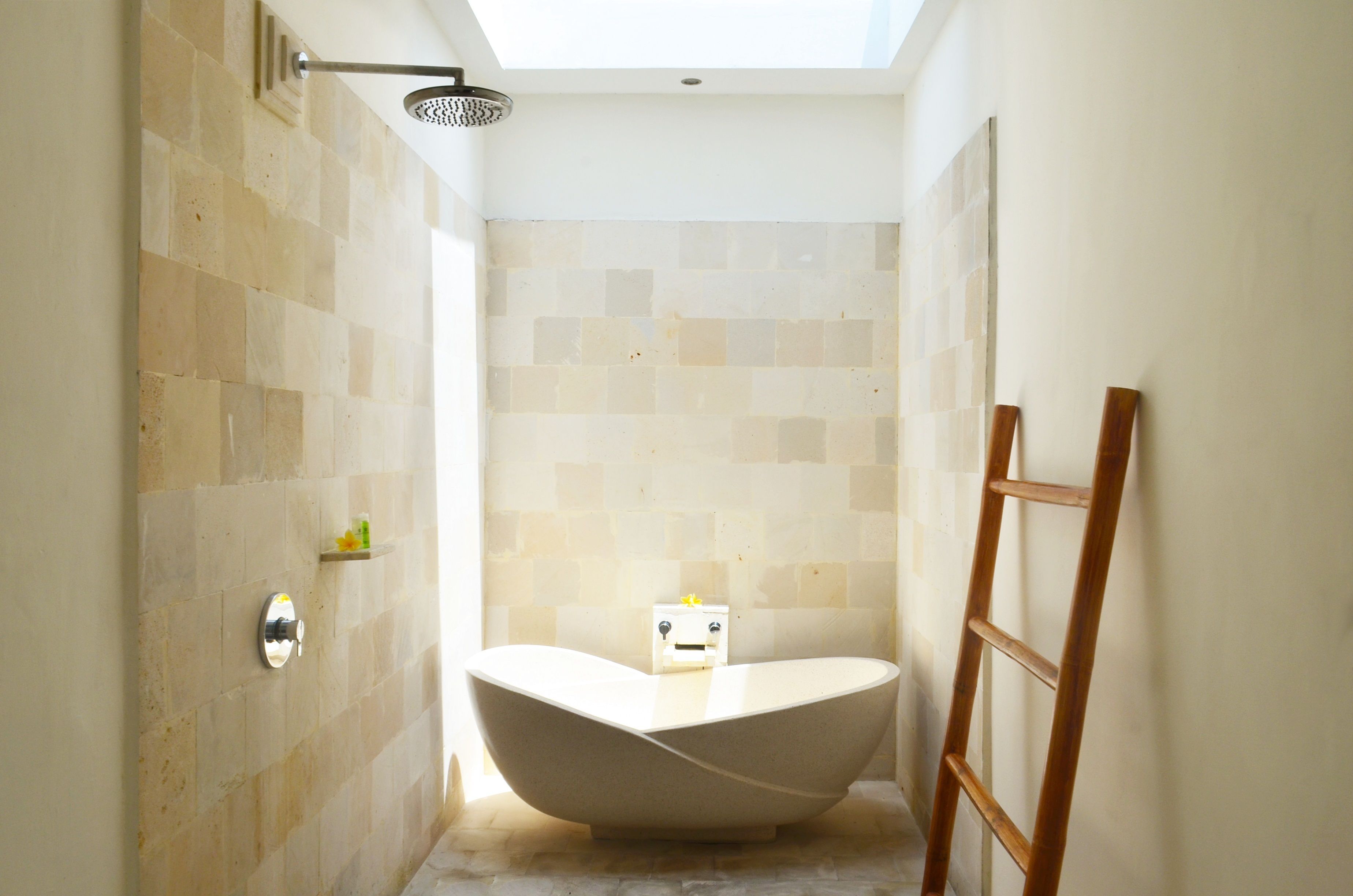 Un baño moderno con una bañera independiente, un cabezal de ducha y una escalera de madera.