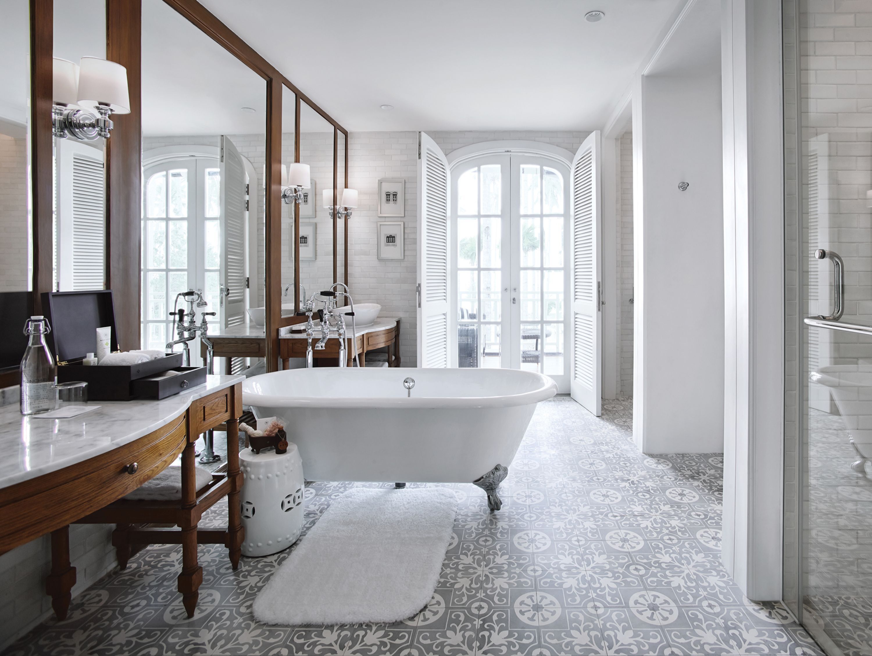 A modern bathroom with a freestanding bathtub, a vanity with a mirror, and a large window providing natural light.