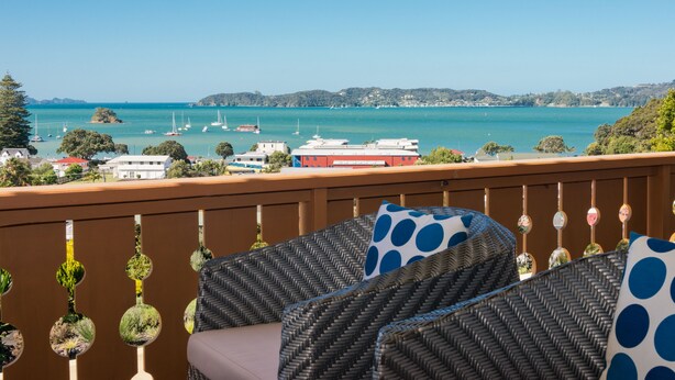 A balcony with wicker furniture and a view of the sea. - Chalet Romantica (Paihia)