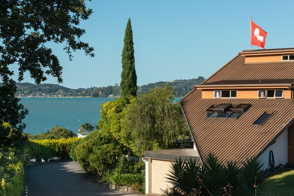A house with a sloped roof, a flag, and a view of a lake.