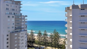 A high-rise building with multiple balconies overlooking a beach and ocean. - Horizons Holiday Apartments (Burleigh Heads)