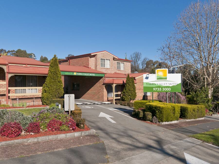 Ein Hotel im Yarra Valley mit Ziegelvorbau, rotem Dach und einem Schild mit dem Namen und der Telefonnummer des Hotels.