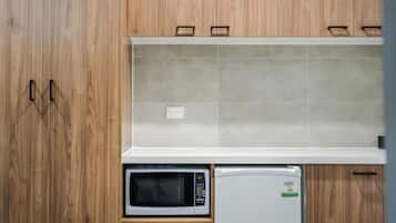 A kitchen with wooden cabinets, a microwave, and a refrigerator.