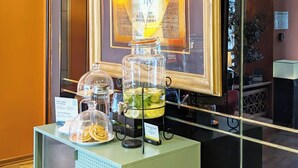 A buffet setup with a glass pitcher of lemonade, a glass jar of cookies, and a glass pitcher of iced tea. - Garner Hotel Hamburg Wandsbek Marktplatz by IHG (Hamburg)
