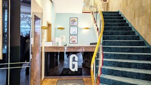 A hotel reception area with a staircase leading to an upper floor. - Garner Hotel Hamburg Wandsbek Marktplatz by IHG (Hamburg)