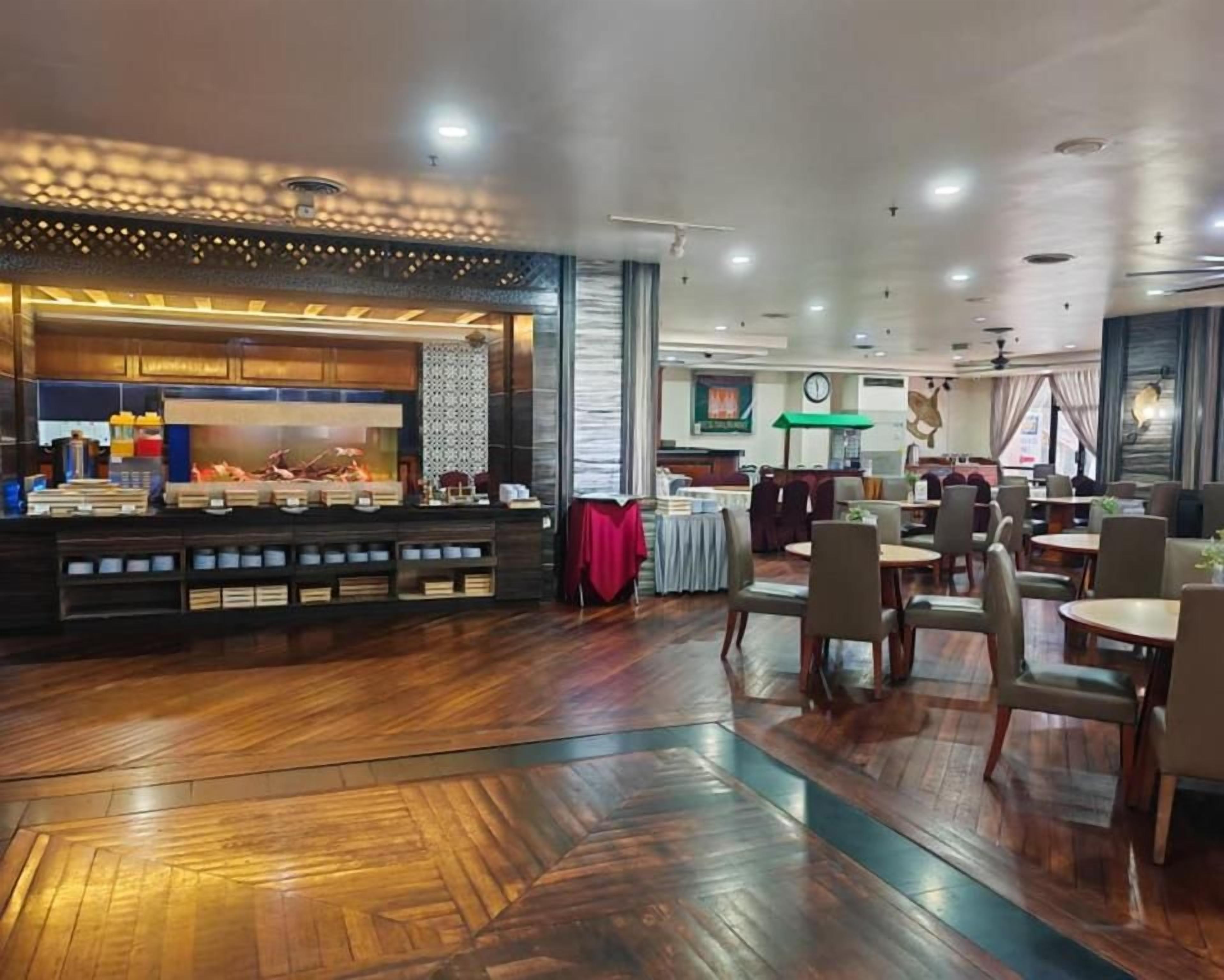 A restaurant with a bar area, wooden flooring, and seating arrangements.