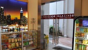 Hoteleingang mit Blick auf die Stadt, eine gekühlte Vitrine und ein Verkaufsautomat.