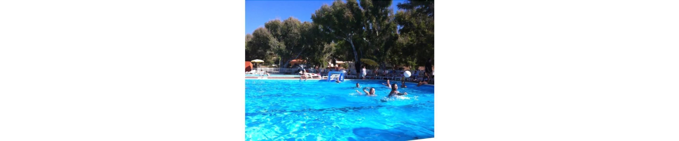Una piscina con gente divirtiéndose en el agua.