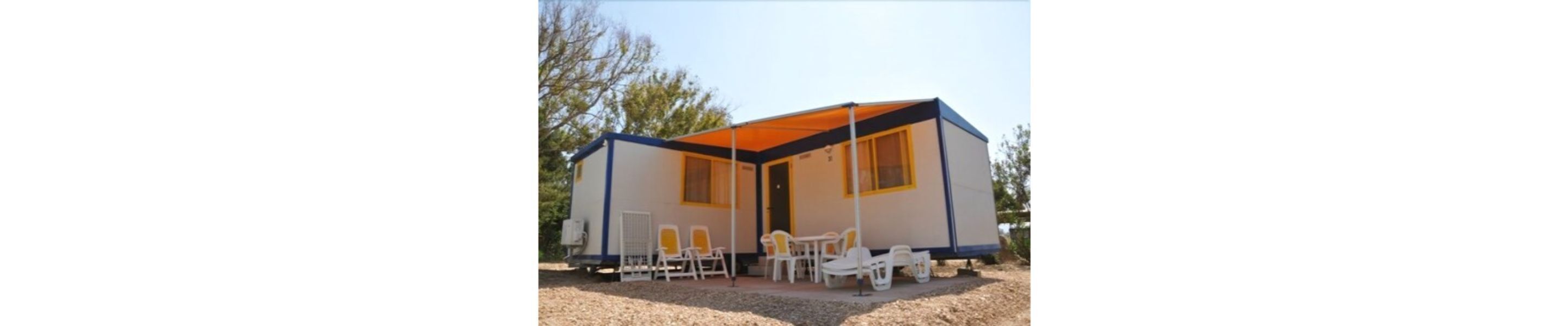 A small, single-story building with a flat roof and a covered patio area.