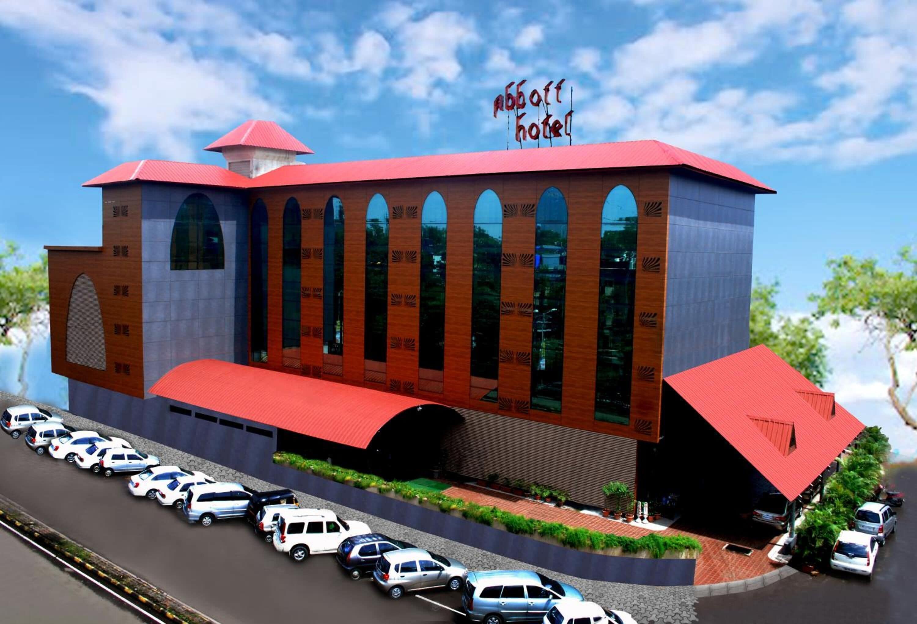A modern hotel with a red roof and multiple arched windows.