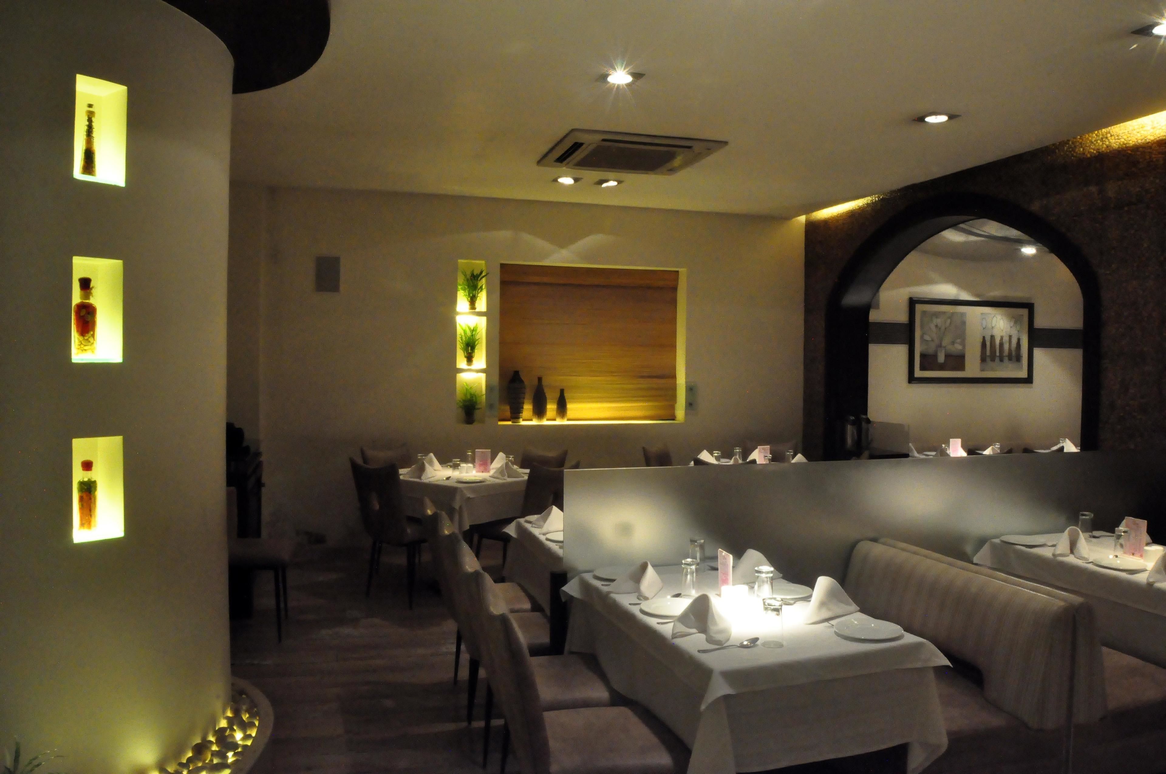 Un restaurante con mesas dispuestas para comer, una pared decorativa de madera y un cuadro en la pared.