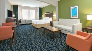 A hotel room with a bed, a desk, a chair, a sofa, and a TV. - Holiday Inn Express Hotel & Suites Monahans - I-20 by IHG (Monahans)