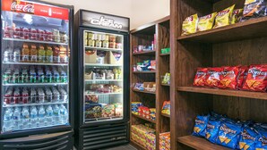 A vending machine with Coca-Cola and ice cream, and shelves stocked with snacks like Doritos and chips. - Holiday Inn Express Hotel & Suites Monahans - I-20 by IHG (Monahans)