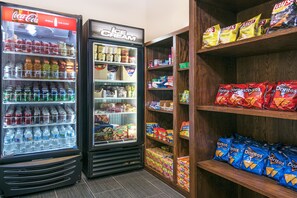 A vending machine with Coca-Cola and ice cream, and shelves stocked with snacks like Doritos and chips. - Holiday Inn Express Hotel & Suites Monahans - I-20 by IHG (Monahans)