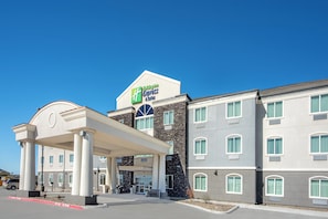 A Holiday Inn Express & Suites hotel with a covered entrance and multiple windows.
