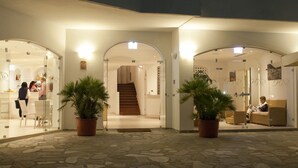 A hotel lobby with a stone floor, potted plants, and a staircase leading to the upper floors. - Hotel Paradiso Residence (Castellabate)