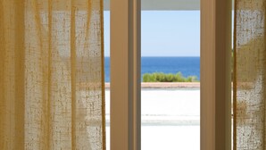 A view through a window with a textured curtain, revealing a beach and ocean. - Hotel Paradiso Residence (Castellabate)