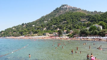 En la playa, arena blanca, sillas reclinables de playa, sombrillas