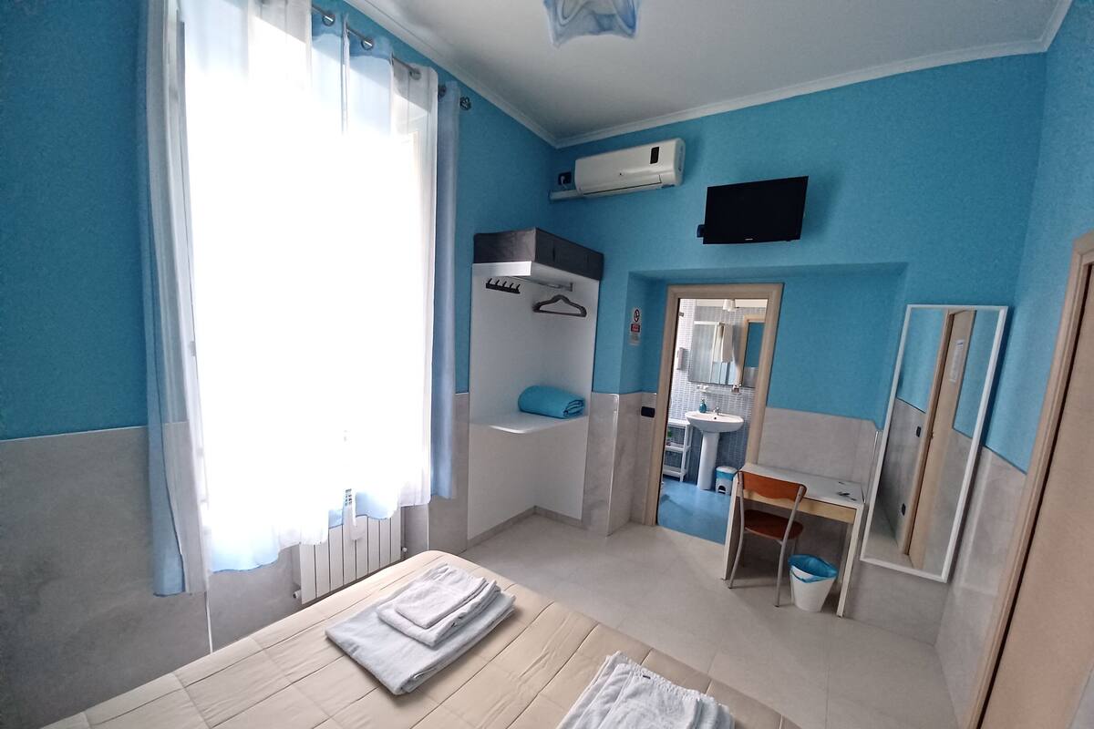A bedroom with a bed, a bathroom, and a TV.