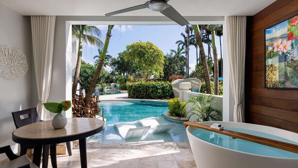 A modern room with a pool, a jacuzzi, and a view of a tropical garden. - Sandals Barbados - ALL INCLUSIVE Adults Only (Maxwell)