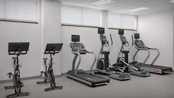 A fitness room with treadmills, elliptical machines, and stationary bikes.
