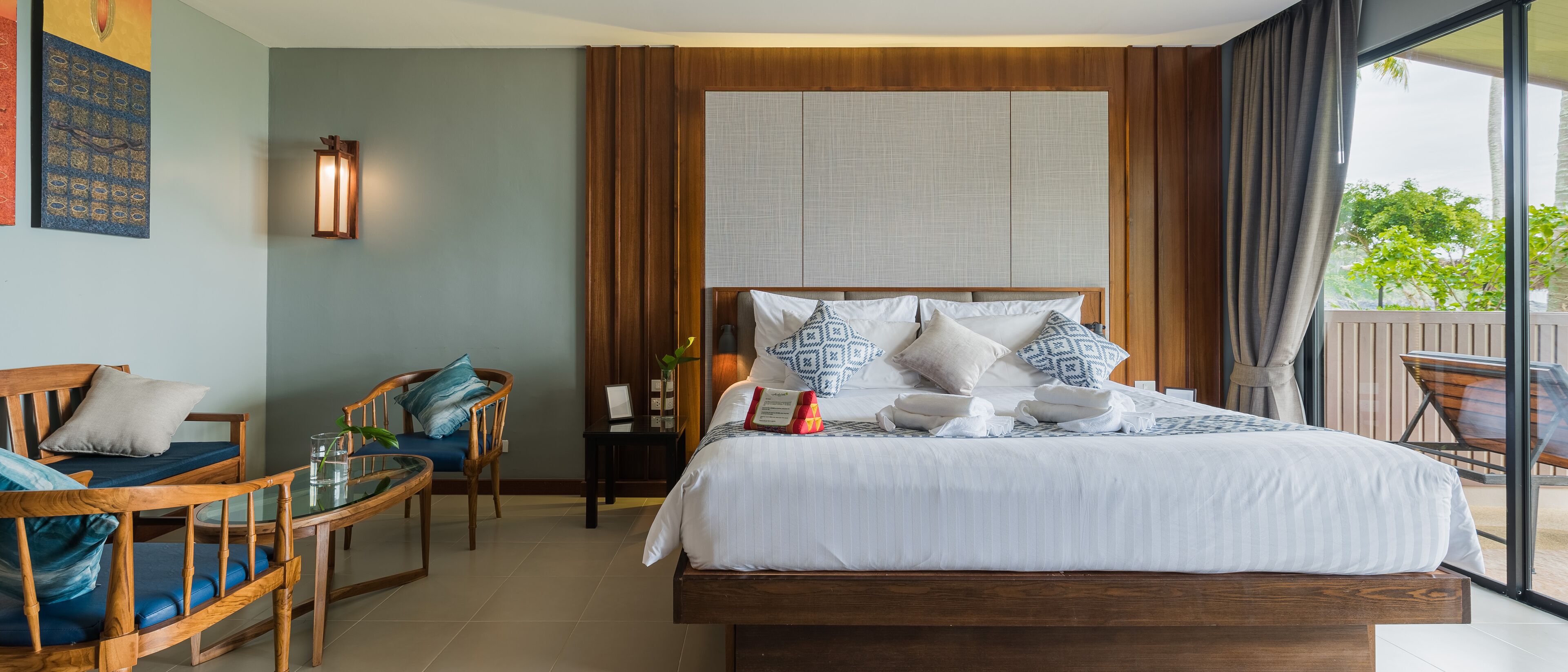 Une chambre d’hôtel avec un grand lit, des meubles en bois et une vue sur l’extérieur.