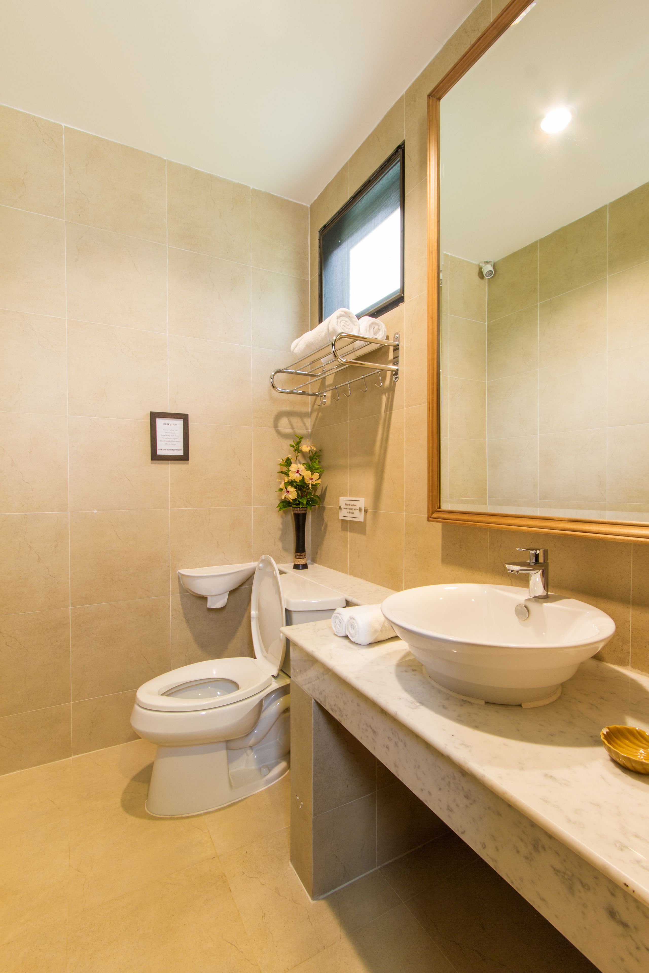 A modern bathroom with a toilet, sink, and mirror.