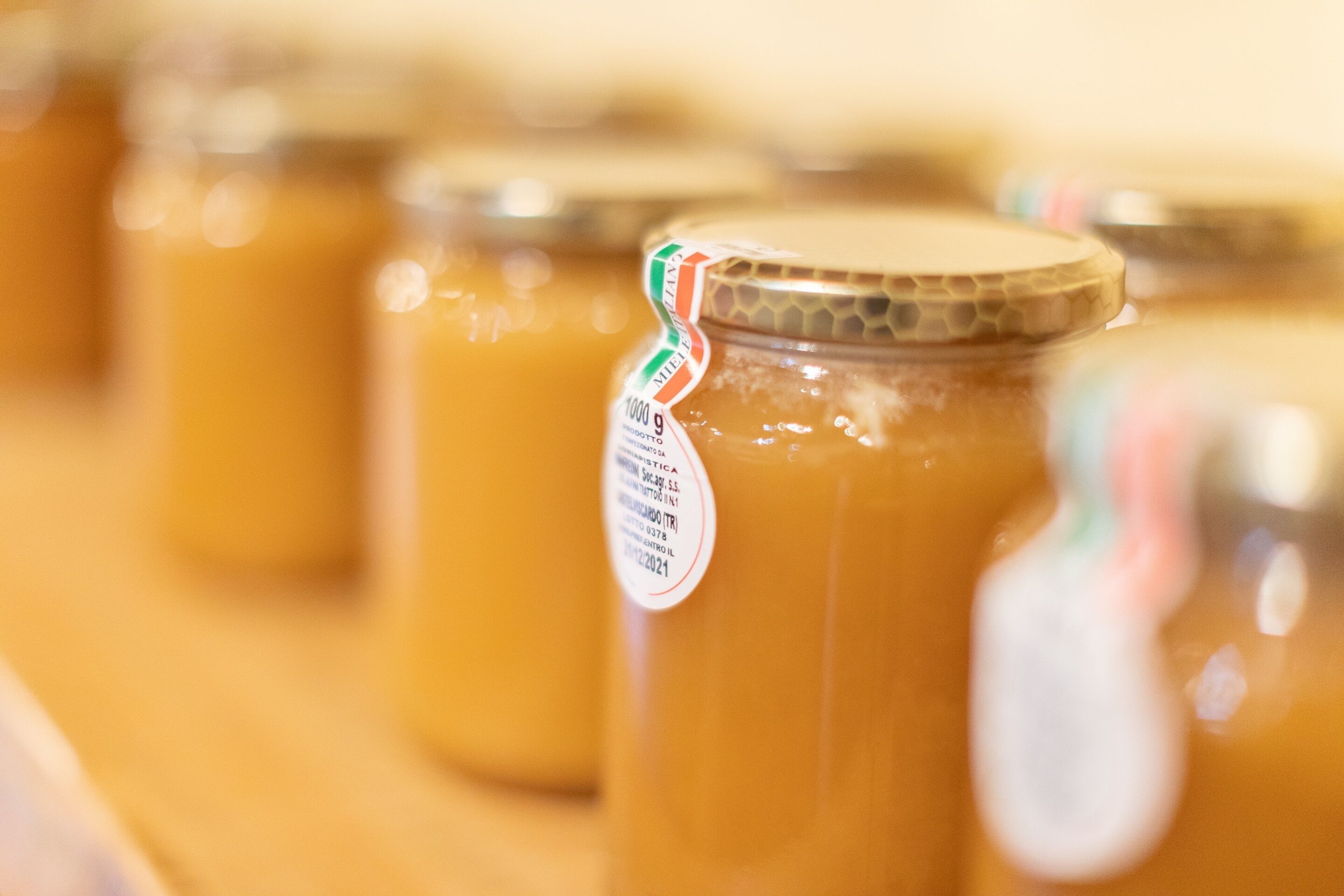 A close-up of several jars of honey with labels.