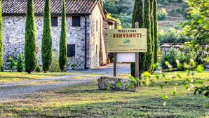 Un edificio de piedra con un cartel que dice "Welcome Benvenuti" e información de contacto para "Poderi San Giorgio".