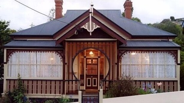 A traditional house with a symmetrical facade, a central entrance with a decorative arch, and a pitched roof with chimneys. - The Duck House (Burnie)