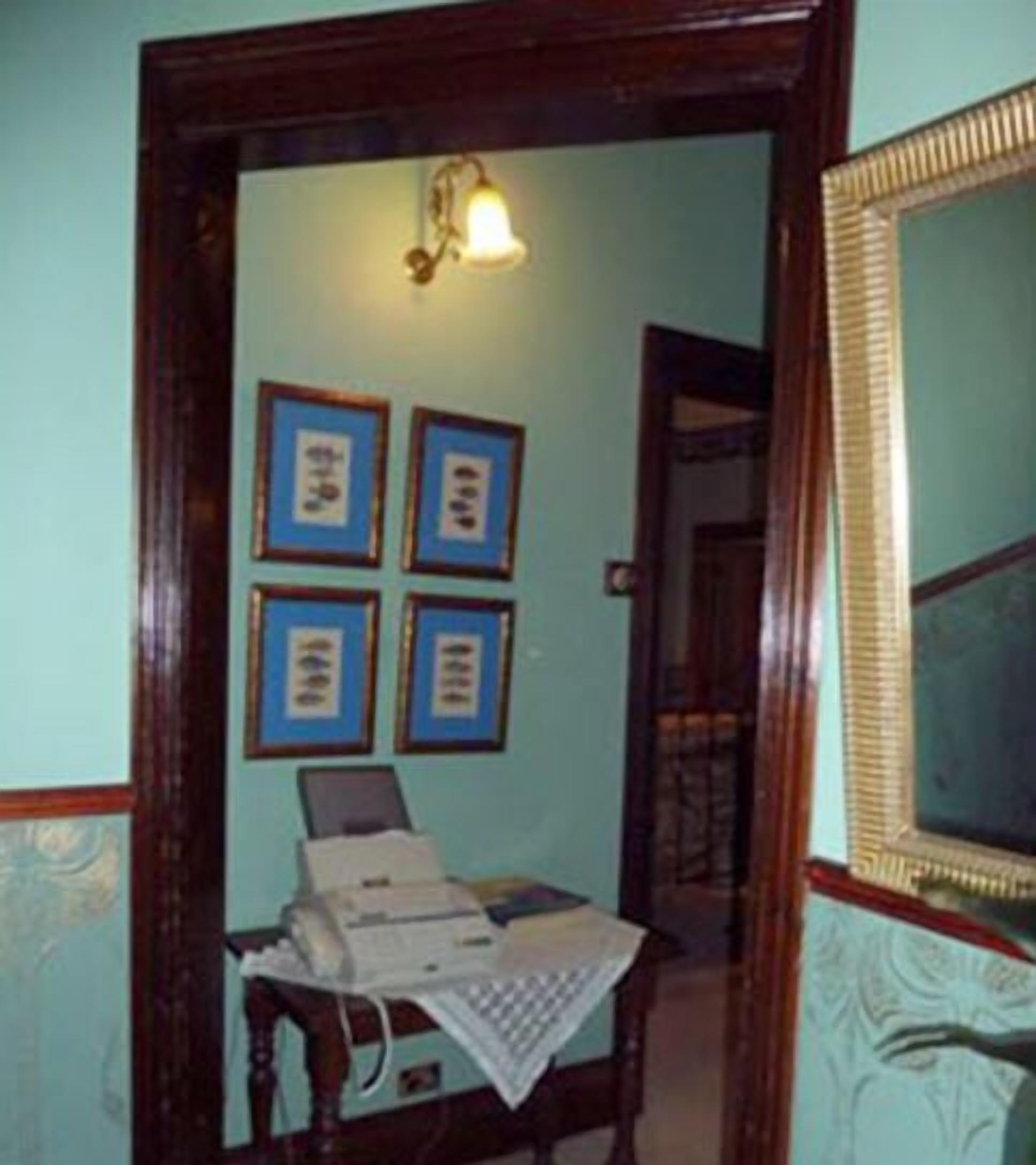 A room with a desk, a telephone, and four framed certificates on the wall.