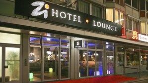 A hotel lounge with a prominent sign, glass doors, and a red carpet entrance. - Zi Hotel & Lounge (Karlsruhe)