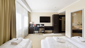 A hotel room with a bed, a desk, a TV, and a bathroom. - Zi Hotel & Lounge (Karlsruhe)