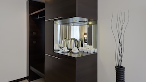 A modern kitchen with dark cabinetry, a built-in stove, and a vase with branches. - Zi Hotel & Lounge (Karlsruhe)