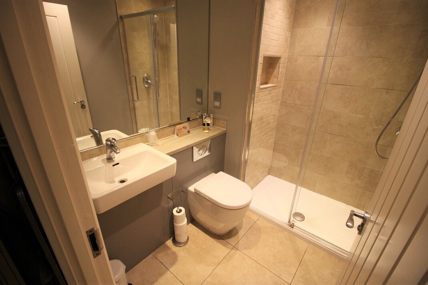 Un baño moderno con lavamanos, inodoro y ducha.
