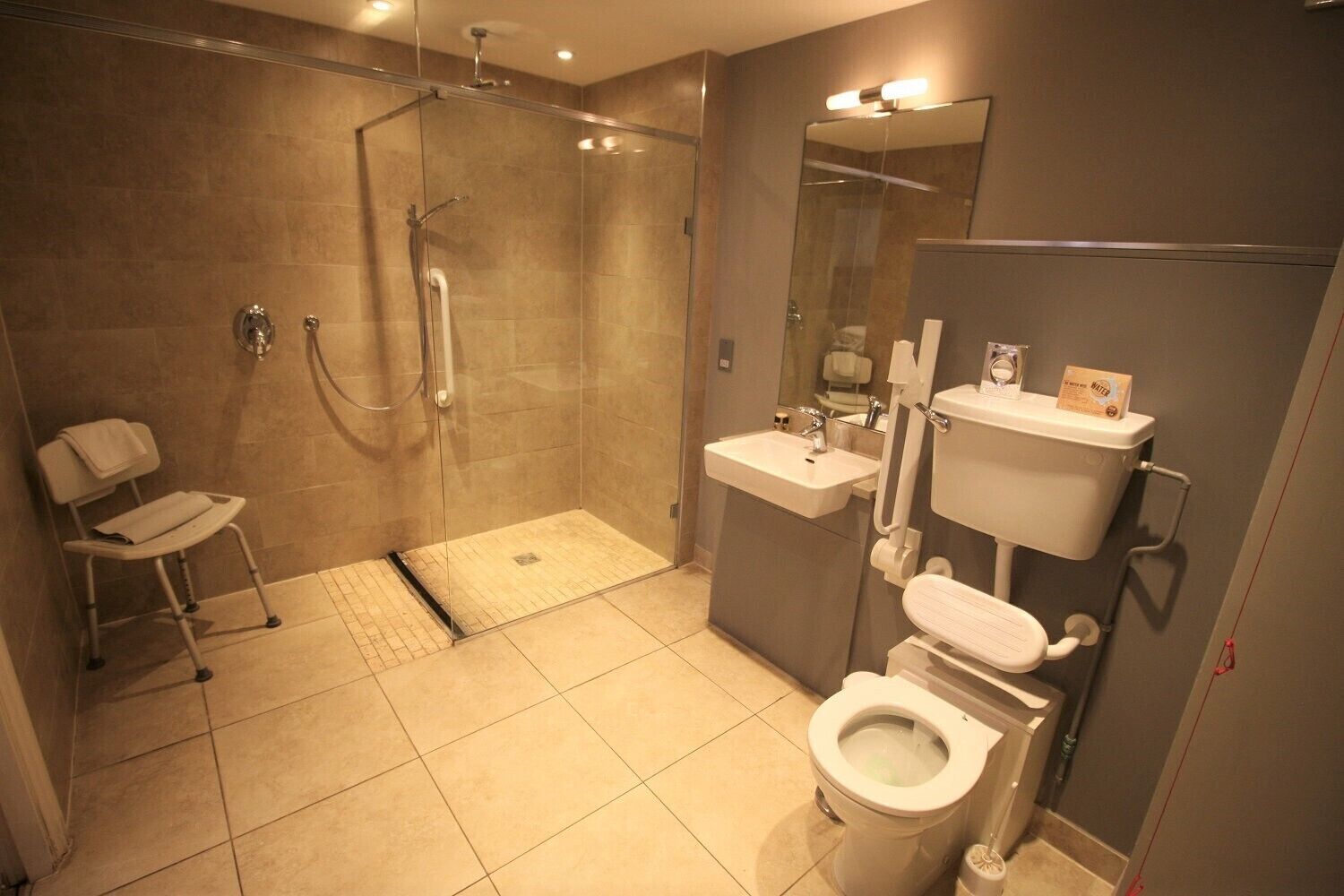 A modern bathroom with a shower, toilet, and sink.