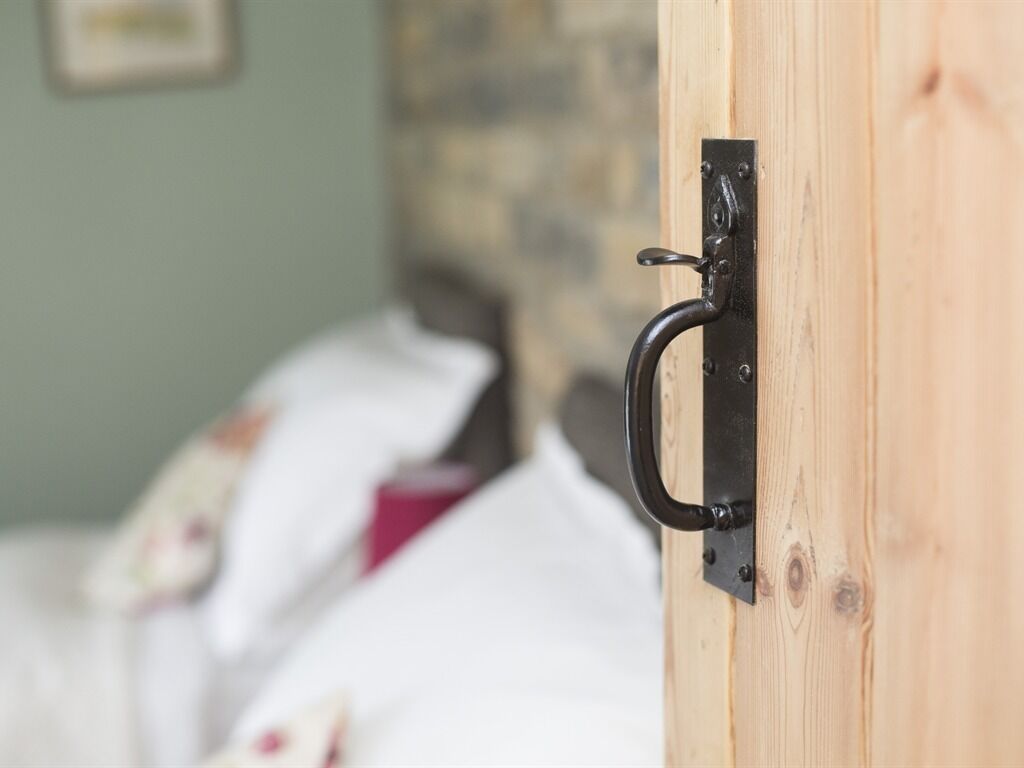 A wooden door with a black metal handle.