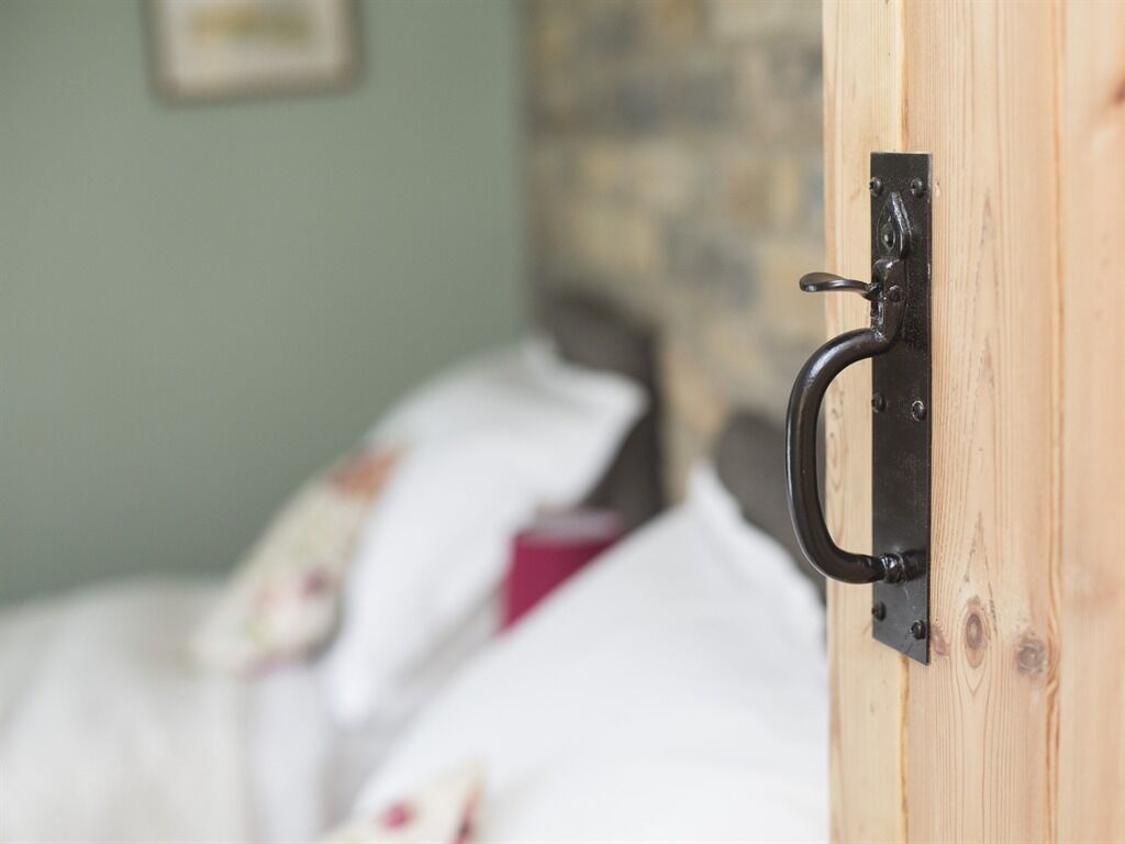 A wooden door with a black metal handle.