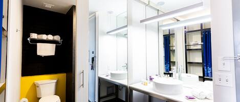 A modern bathroom with a white toilet, a sink, and a mirror.