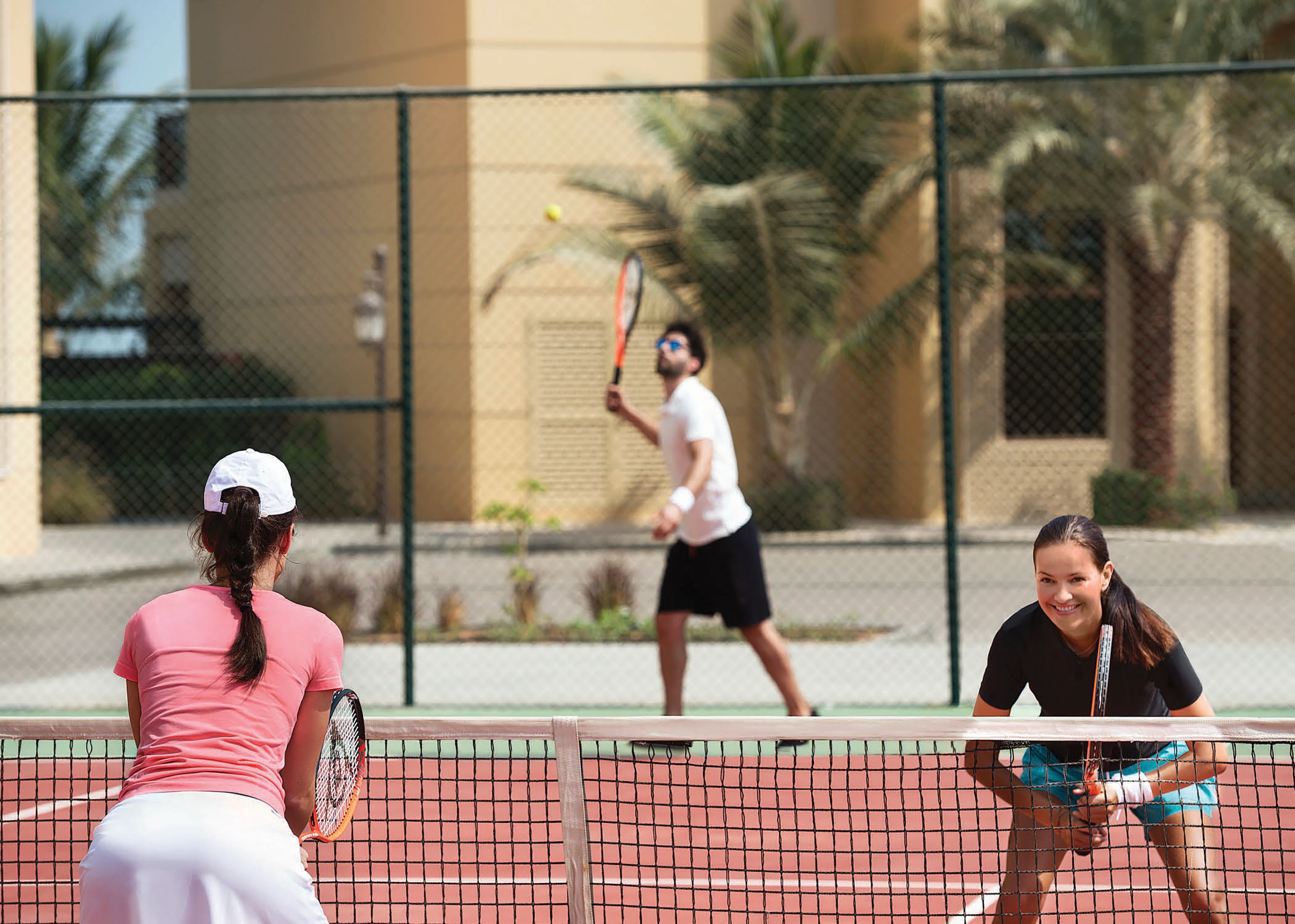 Ein Tennisplatz mit spielenden Personen.