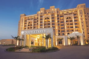 A large, multi-story hotel with a prominent entrance and a sign reading 'DOUBLETREE BY HILTON'.