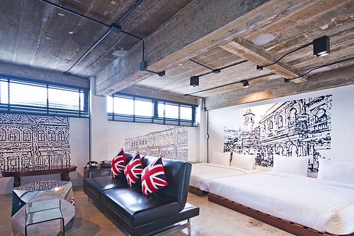 Ein modernes Hotelzimmer mit einem großen Bett, einer schwarzen Ledersofa und einem Wandbild.