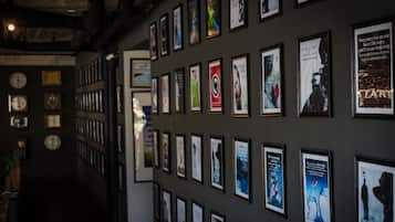 Una pared con varios carteles y relojes enmarcados.