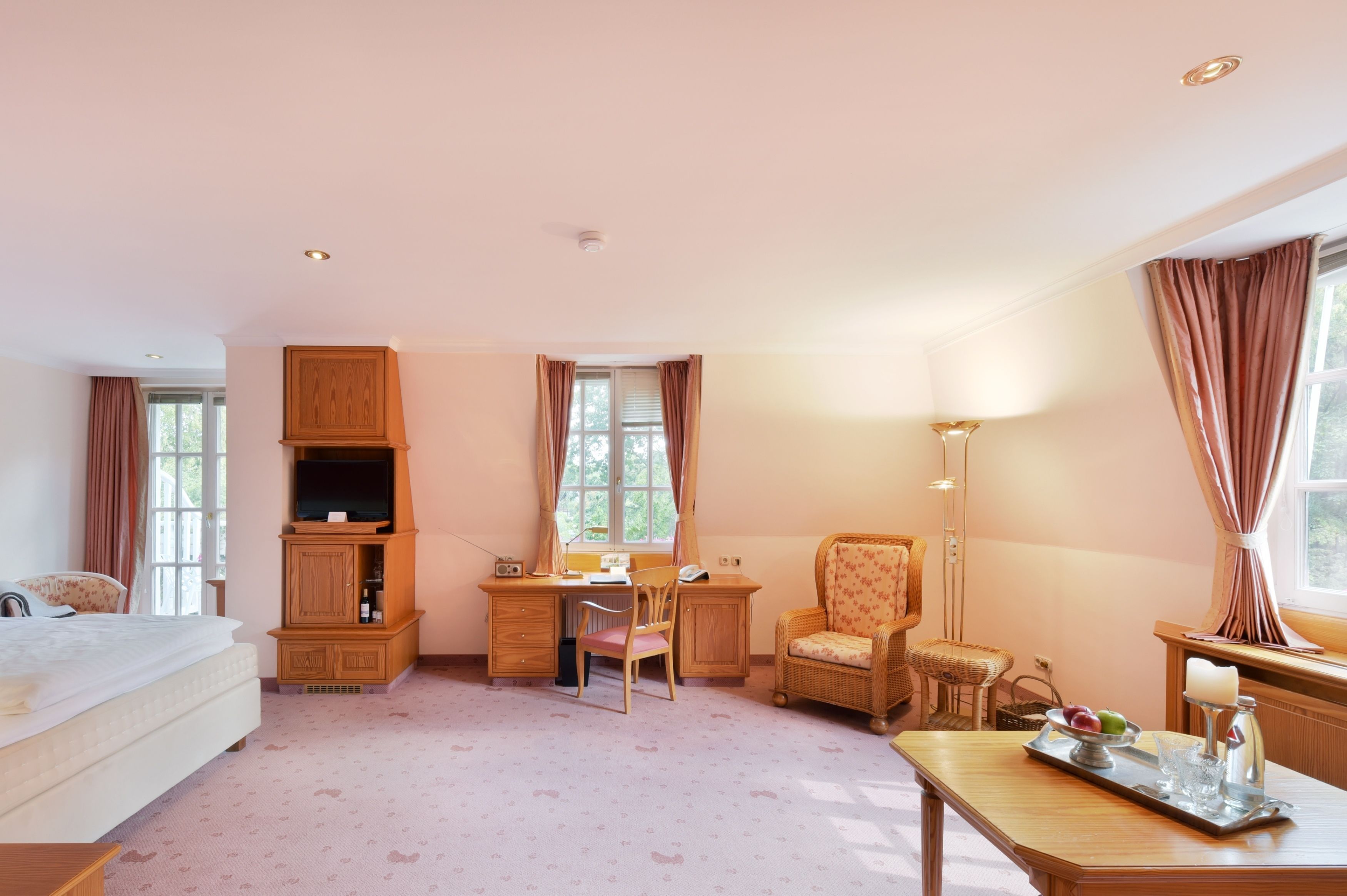 Una habitación de hotel acogedora con cama, escritorio, silla y mesa de comedor.