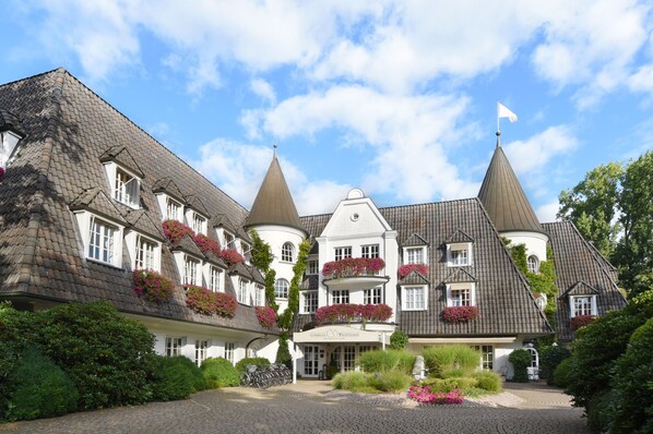 A traditional European-style hotel with multiple towers, a central courtyard, and a flag on top. - Hotel Landhaus Wachtelhof (Rotenburg)
