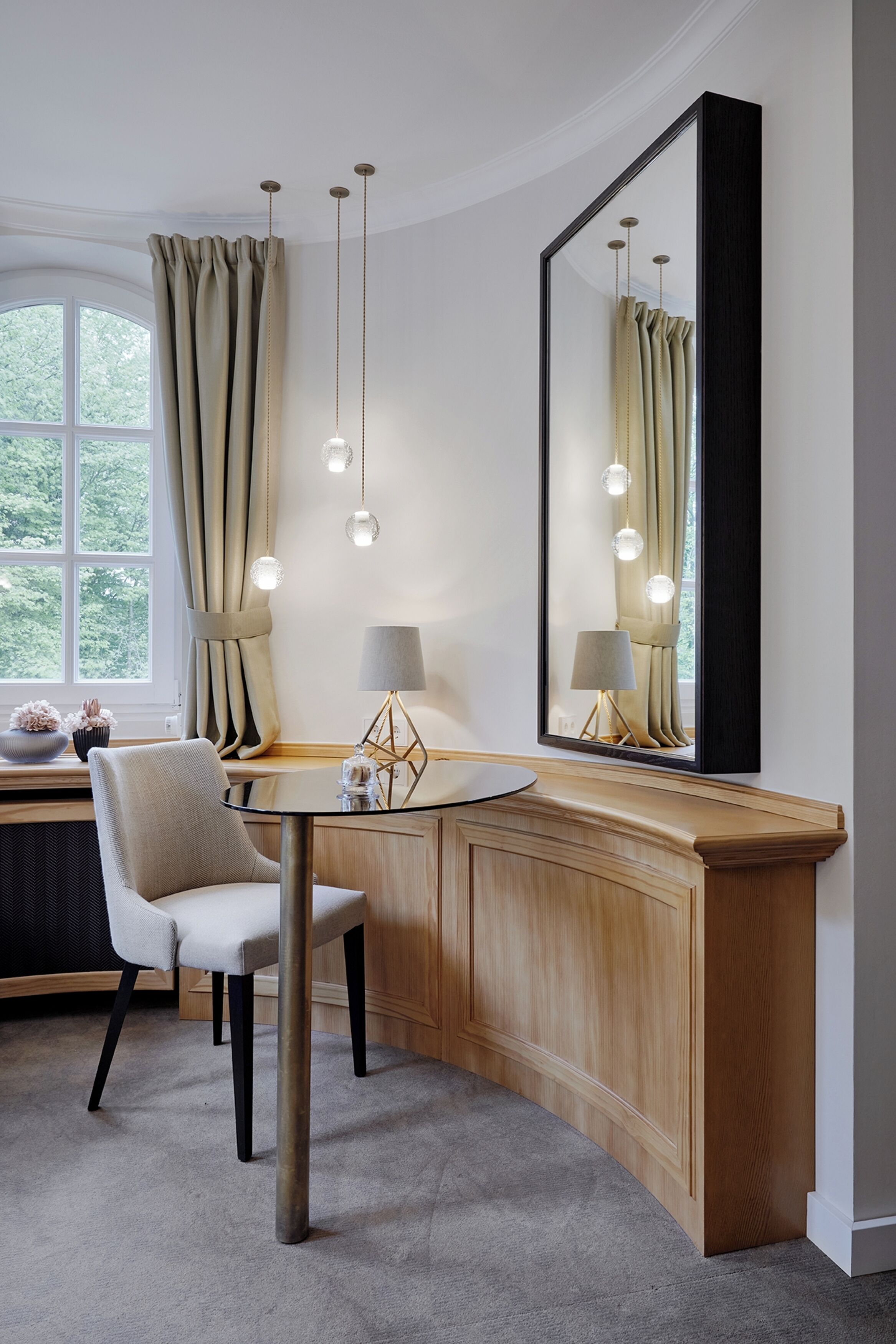 Een moderne badkamer met een houten wastafelmeubel, een grote spiegel en een raam met gordijnen.