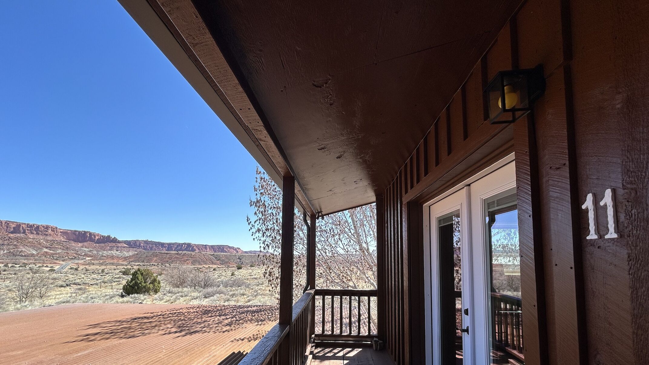 Eine hölzerne Veranda mit Blick auf eine Wüstenlandschaft und Berge.