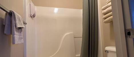 A bathroom with a bathtub, toilet, and a shower curtain.