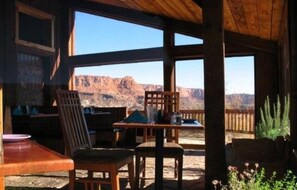 A wooden interior with large windows overlooking a mountainous landscape.