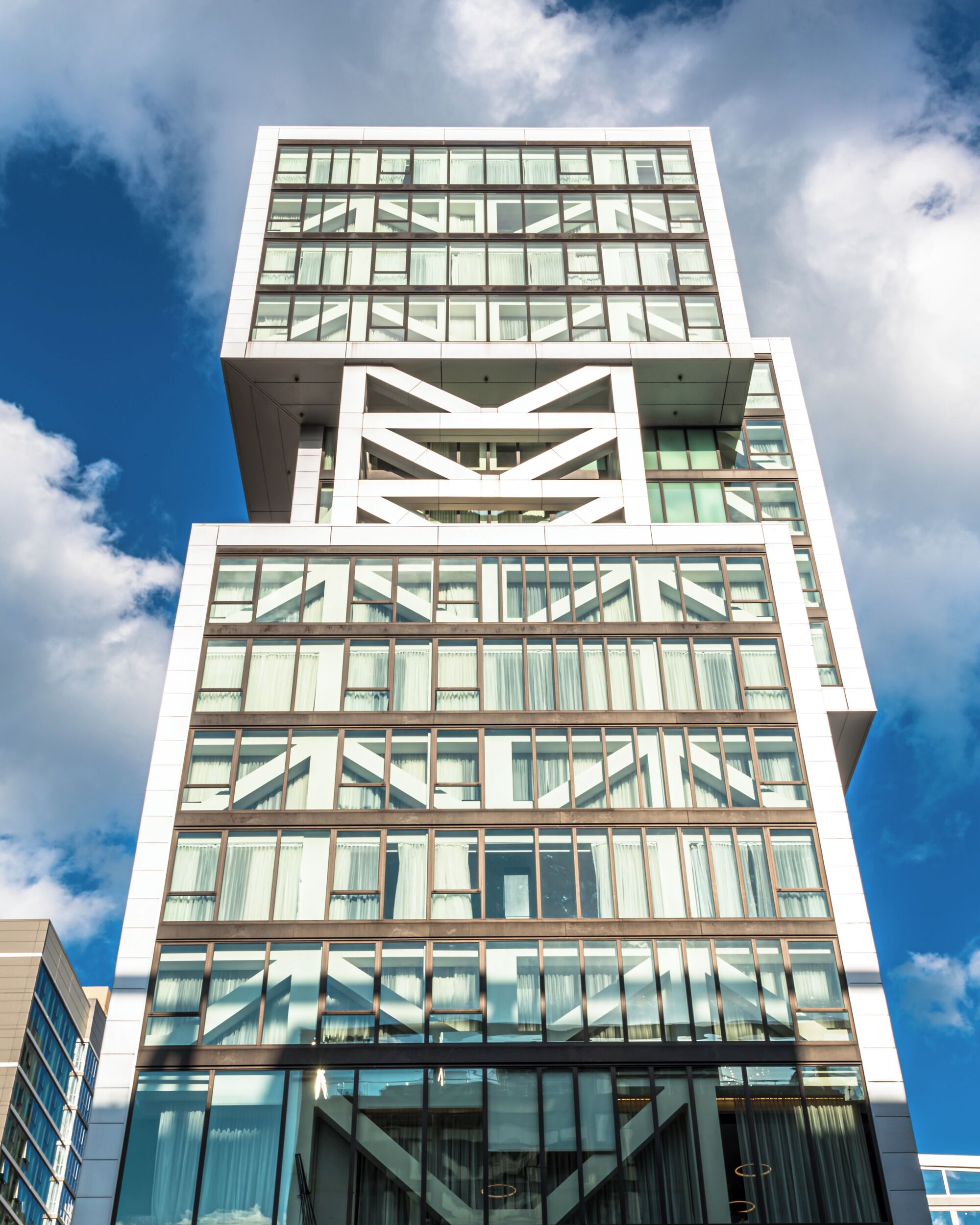 Un edificio moderno de varios pisos, con grandes ventanales y un diseño geométrico en la fachada.